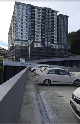 a parking lot with cars parked in front of a tall building at SA @ Cameron Emerald Avenue in Brinchang