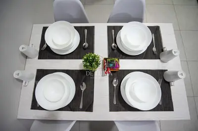 a table with white plates and forks and spoons at De Luma - Meritus in Perai