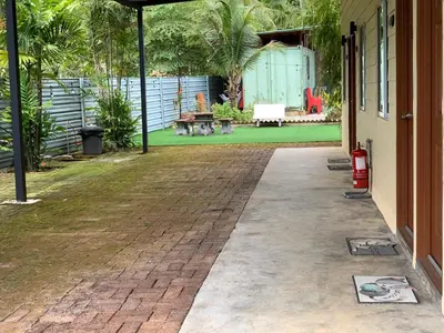 a brick walkway outside of a house with a yard at Raintown Cottage in Taiping