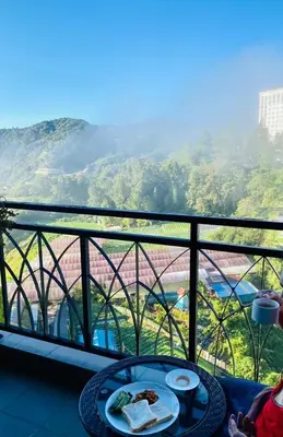 a table with food on a balcony with a view at Dzulstudio(Muslim) Nova Highland in Brinchang