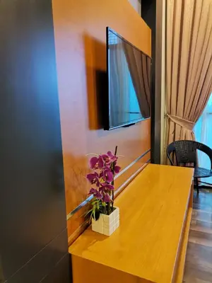 a wooden table with a vase of flowers on it at Dzulstudio(Muslim) Nova Highland in Brinchang