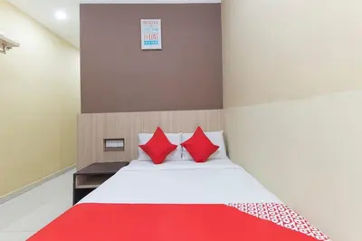 a bedroom with a bed with red pillows at Silibin Times Inn Hotel in Ipoh