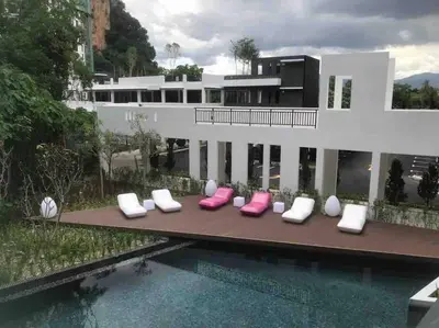 a house with pink and white pillows next to a swimming pool at Ipoh Tambun Cove Luxe Premium Suites in Ipoh