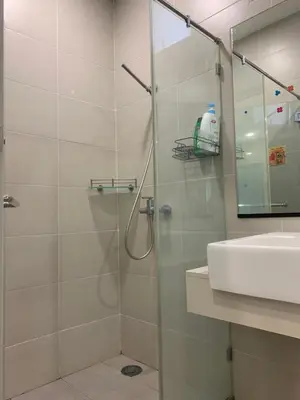 a bathroom with a glass shower with a sink at Straits Garden Suites by Yen's Sojourn in George Town