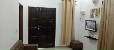 a living room with a black door and a television at D'NAS HOMESTAY - Muslm Only in Sungai Besar