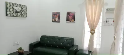 a living room with a green couch and a window at D'NAS HOMESTAY - Muslm Only in Sungai Besar
