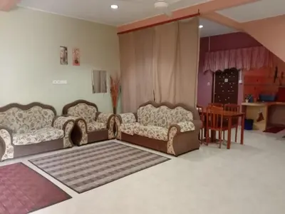 a living room with two couches and a table at Sobey Laris Homestay CHIKU1 in Gua Musang