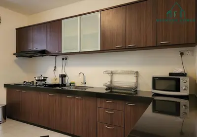 a kitchen with wooden cabinets and a microwave at 99 Kelawei in George Town