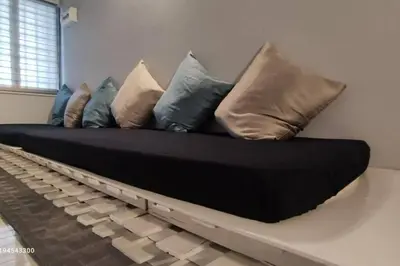 a couch with pillows on it in a room at Margosa Botani Ipoh Homestay 3BR by Grab A Stay in Ipoh