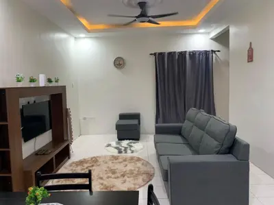 a living room with a couch and a tv at Homestay Maryam in Lumut
