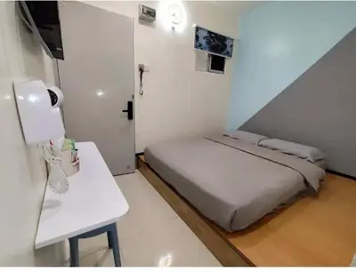 a small white room with a bed and a table at MUSANG ONG HOTEL in Cameron Highlands