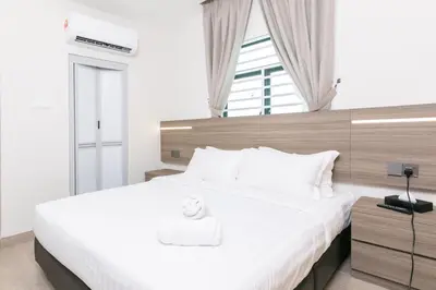 a bedroom with a large white bed and a window at E Hotel Kulim in Kulim
