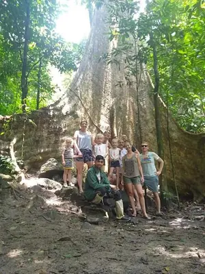 a group of people standing in front of a tree at Royal Belum Mystical in Gerik