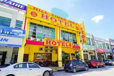 a yellow hotel with cars parked in front of it at Hill Times Inn Hotel in Ipoh