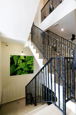 a staircase with black railings and a painting on the wall at Golden Lodge in Tanah Rata