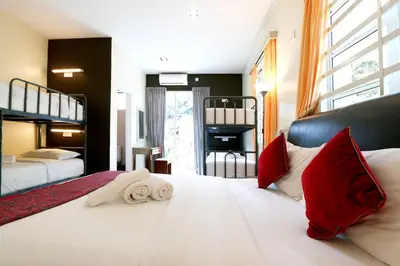a bedroom with two beds with red and white pillows at Golden Lodge in Tanah Rata
