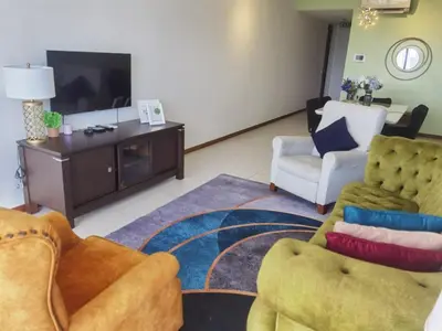 a living room with two chairs and a tv at Tree Family Executive Suite 3 BR /8 PAX Gurney in Tanjong Tokong