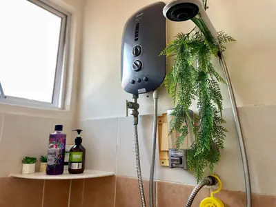 a shower in a bathroom with a plant at Zarahome in Tambun