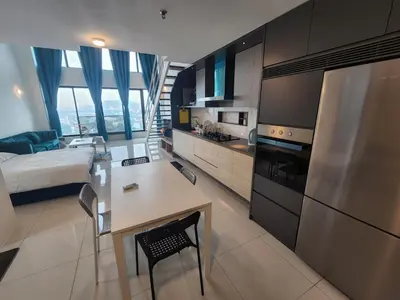 a kitchen with a desk and a kitchen with a bed at Sunrise Gurney Premium Suite - Gurney Drive in George Town