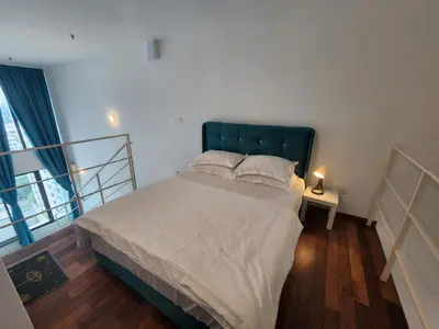 a bedroom with a large bed with a green headboard at Sunrise Gurney Premium Suite - Gurney Drive in George Town