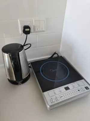 a coffee pot and a toaster on a counter at Sunrise Gurney Premium Suite - Gurney Drive in George Town