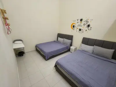 two beds in a bedroom with purple sheets at My Homestay Sitiawan - Astronaut Space House 8 Pax in Sitiawan