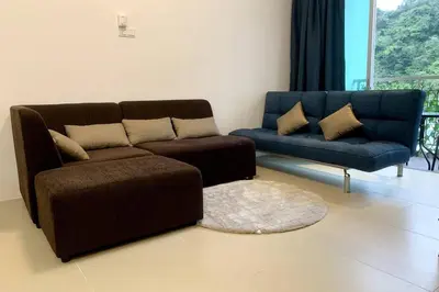 a living room with a brown couch and a blue sofa at New GoldenHill Condo 3BR 1Min Pasar Mlm Cameron Highlands in Tanah Rata