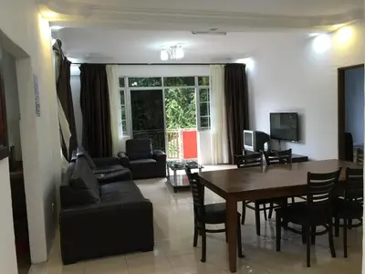 a living room with a table and a dining room at Cameron Pasar Malam Apartment @ Crown Imperial Court in Cameron Highlands