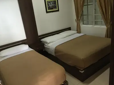 two beds in a small room with a window at Cameron Pasar Malam Apartment @ Crown Imperial Court in Cameron Highlands