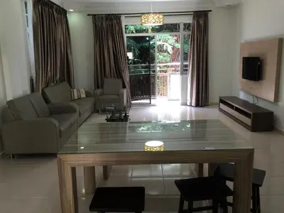 a living room with a table and a couch at Cameron Pasar Malam Apartment @ Crown Imperial Court in Cameron Highlands