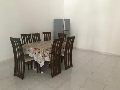 a dining room table with chairs and a tablecloth on it at 66 Semi-D Homestay in Teluk Intan
