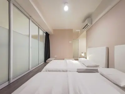 a bedroom with two beds and a large window at Maritime Suites Penang in Jelutong