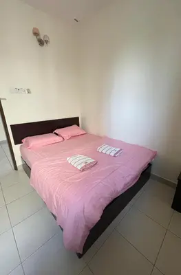 a bedroom with a pink bed with two pillows on it at Intanova Hotel in Teluk Intan