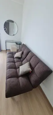 a brown couch in a room with a mirror at Jazz Service Suites 2 Bedroom 23-3 by Yen's Sojourn in Bagan Jermal