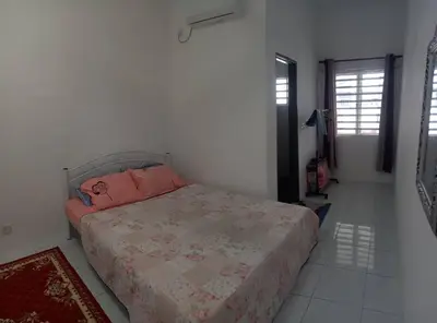 a bedroom with a bed with pink pillows on it at Homestay D'Mama Īfor mūslimĪ in Tanjung Malim