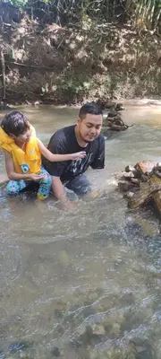a man and a child playing in the water at Hometostay Bokbak Kupang in Kampong Baubak