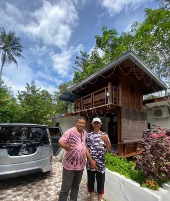 a man and a woman standing in front of a house at Hometostay Bokbak Kupang in Kampong Baubak