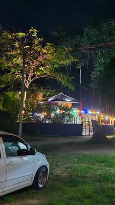 a white car parked in front of a house with lights at Hometostay Bokbak Kupang in Kampong Baubak
