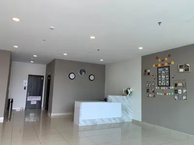 a lobby with a table and clocks on the wall at Hotel Mutiara in Gua Musang