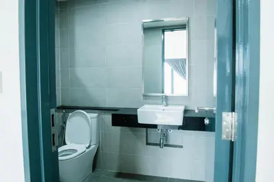a bathroom with a toilet and a sink and a mirror at The Aspen, 3BR Cityview by WStay @Tropicana 218 Macalister in George Town