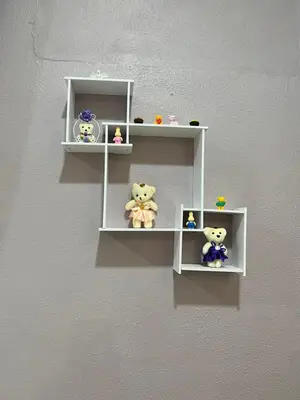 a wall with white shelves with teddy bears on them at Batu Feringgi Homestay in Batu Ferringhi