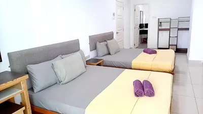two beds in a room with purple shoes on them at Mansion One Entire House 4 QueenBeds - Spacious Balcony Seaview in George Town