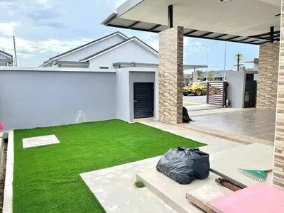 a backyard with a green lawn in front of a house at MMG D'Bertam Homestay For Malay Only in Kampong Permatang Durian