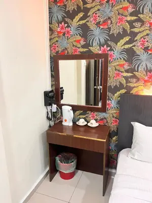 a mirror on a table next to a bed at Hotel Citra in Brinchang
