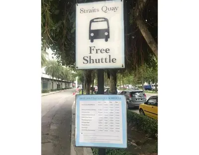 a free shuttle sign on the side of a street at WHITE HOUSE STRAITS QUAY MARINA LUXURY STAY GURNEY in Tanjong Tokong