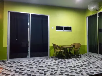 a table and chairs in a room with a green wall at Inap Desa 3 in Kampong Siput
