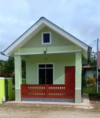 a small green and red house with a red door at Inap Desa 1 in Kampong Siput
