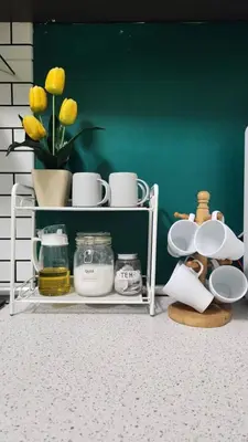a shelf with dishes and a vase with yellow flowers at Homestay De Mutiara Tasek Ipoh in Ipoh