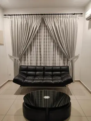 a black leather couch in front of a window at Prestij 3 Homestay, Balik Pulau in Balik Pulau
