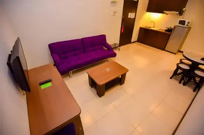 a living room with a purple couch and a table at Ritz Garden Hotel Manjung in Lumut